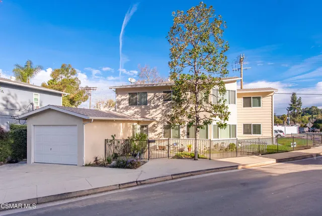 a view of a house with backyard and sitting area
