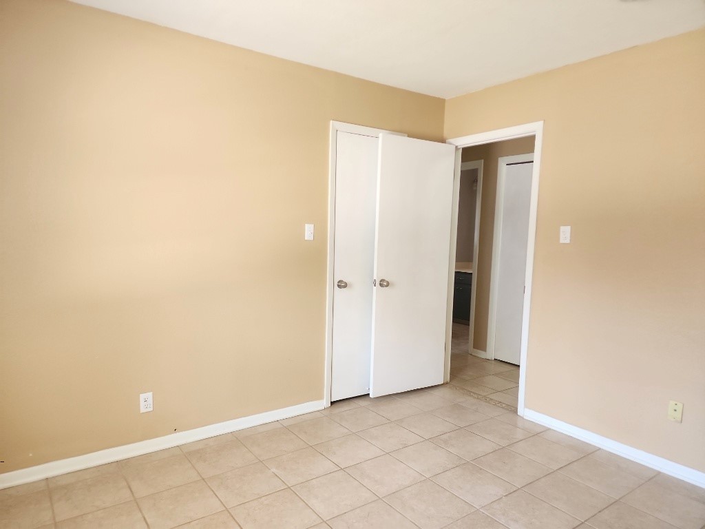 807 Country Club Road Georgetown, TX 78628 - Photo 27 of 31 Unfurnished bedroom with baseboards and light tile patterned floors