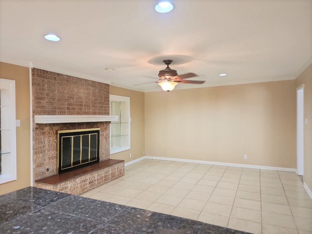 807 Country Club Road Georgetown, TX 78628 - Photo 4 of 31 Unfurnished living room featuring recessed lighting, a fireplace, light tile patterned floors, a ceiling fan, and ornamental molding