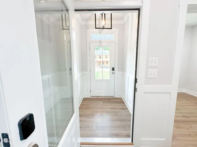 a view of a hallway with wooden floor and entryway