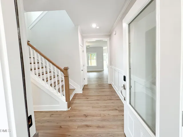 a view of a hallway with wooden floor and staircase
