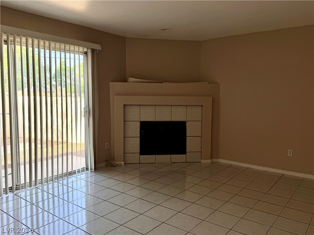 6250 West Flamingo Road, Unit 4 Las Vegas, NV 89103 - Photo 5 of 45 This inviting space features a tiled fireplace and convenient patio access, perfect for comfortable living.