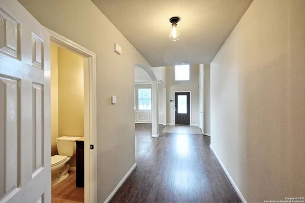 a view of a hallway with wooden floor and closet area