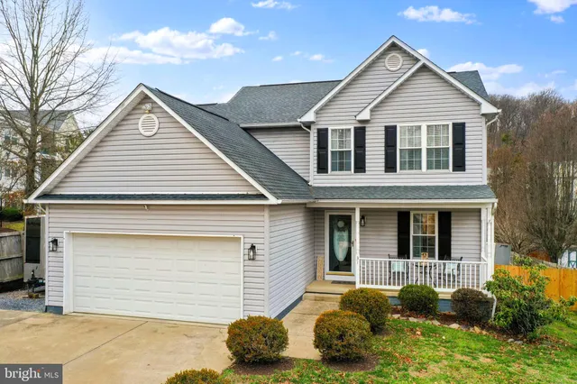 a view of a house with a yard and potted plants