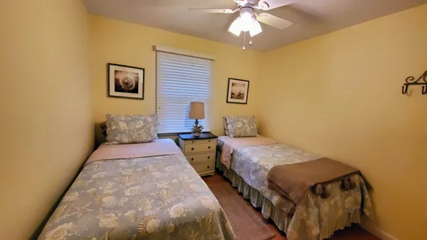 a bedroom with two beds and a chandelier