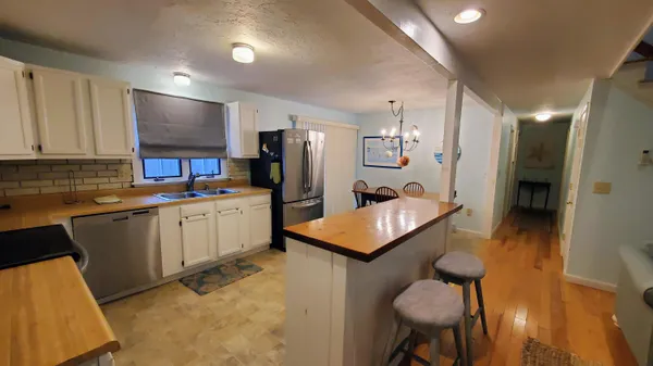 a kitchen with stainless steel appliances kitchen island granite countertop a sink refrigerator and cabinets