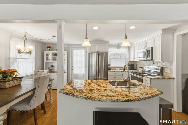 a kitchen with kitchen island stainless steel appliances a sink stove and refrigerator