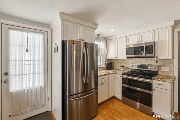 a kitchen with granite countertop a refrigerator stove and microwave