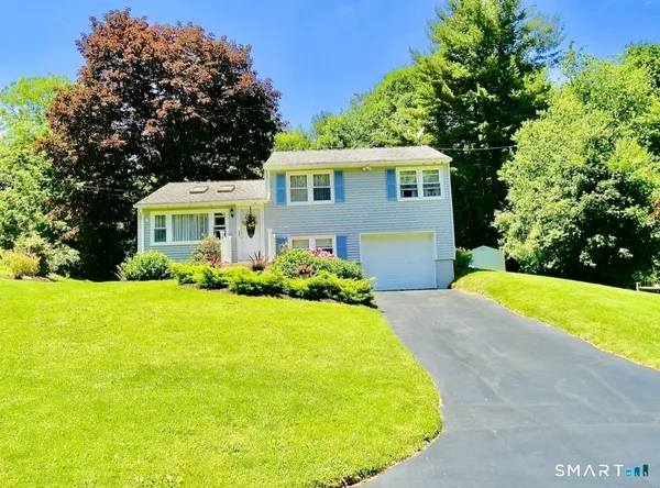a front view of a house with yard and green space