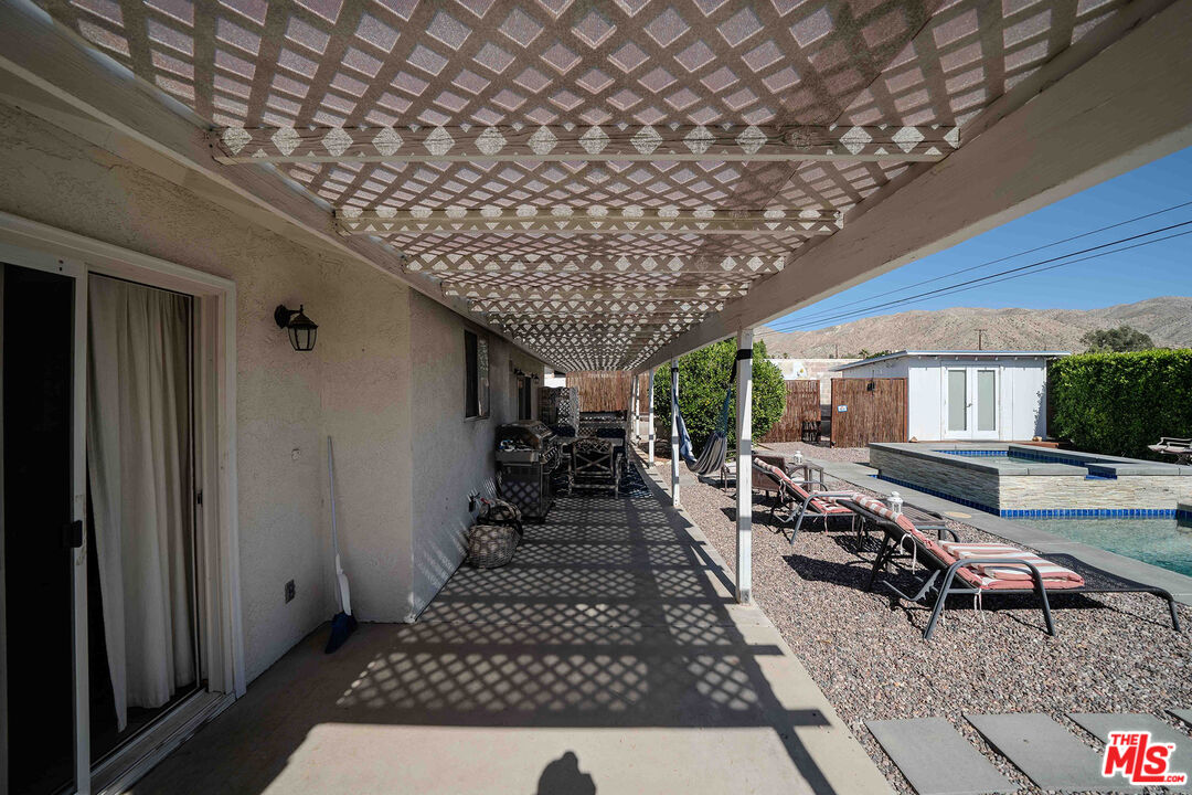 9524 Santa Cruz Road Desert Hot Springs, CA 92240 - Photo 40 of 53 a view of a patio with table and chairs with wooden floor and fence