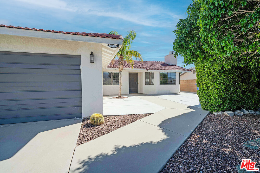 9524 Santa Cruz Road Desert Hot Springs, CA 92240 - Photo 4 of 53 a view of a white house with a large window and flower plants