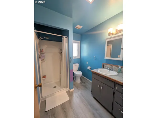 a spacious bathroom with a granite countertop sink a toilet and shower