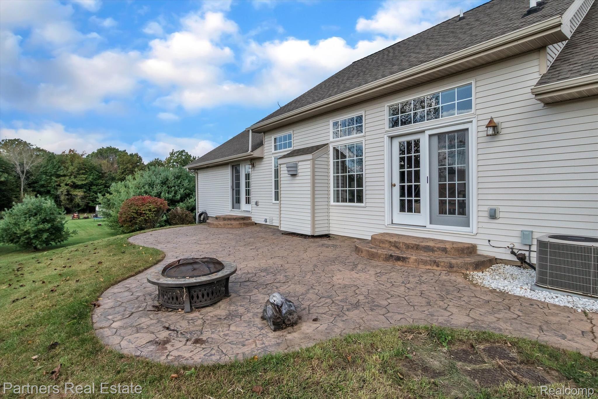 2609 Murray Road Stockbridge, MI 49285 - Photo 50 of 58 Another view of the back of the home and the stamped concrete patio. Two sets of patio doors lead out here.