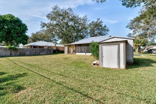 a view of a house with backyard and a tree