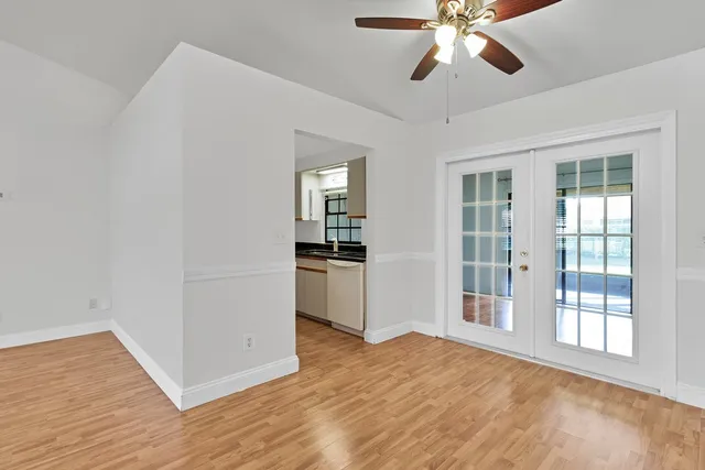 a view of an empty room with window and wooden floor