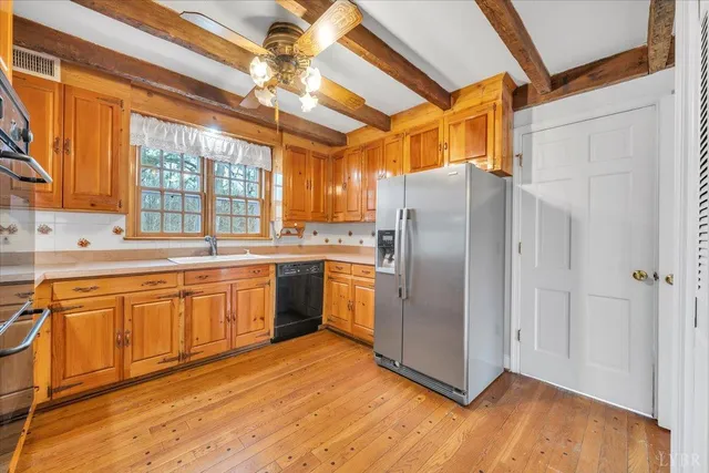 a view of a hallway with wooden floor and a kitchen