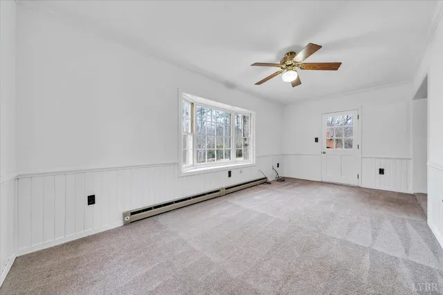 an empty room with wooden floor chandelier fan and windows