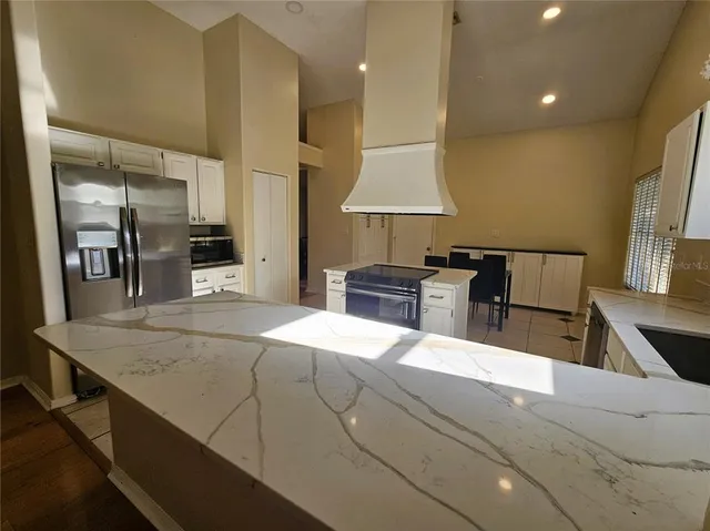 a large kitchen with stainless steel appliances a large counter top