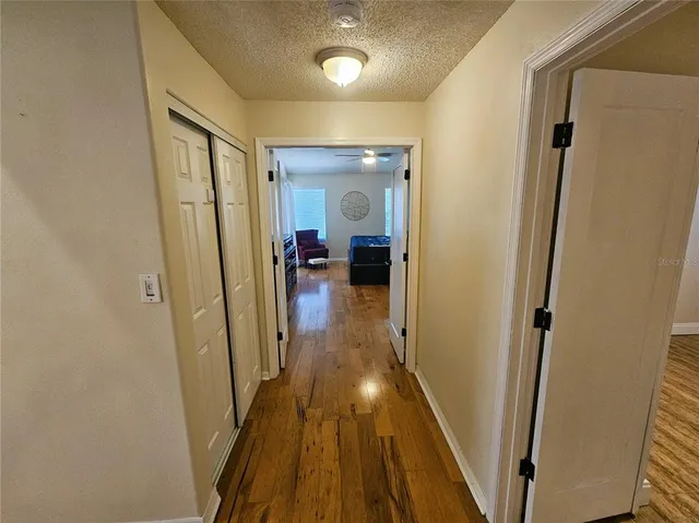 a view of a hallway with wooden floor and furniture