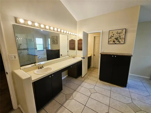 a large bathroom with a sink a mirror and a bathtub