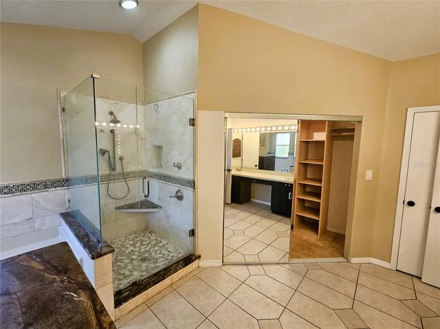 a bathroom with a granite countertop sink and shower