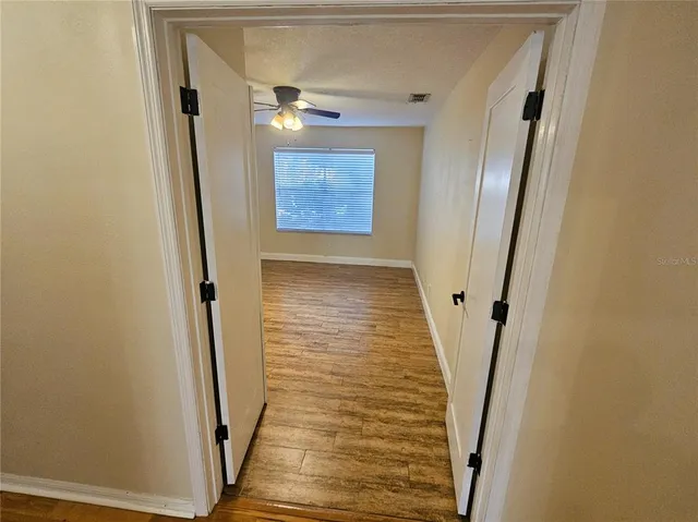 a view of a hallway with wooden floor and staircase