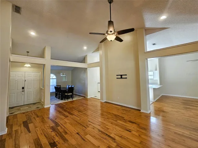 a view of a livingroom with a furniture a ceiling fan and wooden floor