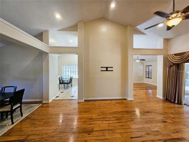 a view of a livingroom with wooden floor and a ceiling fan