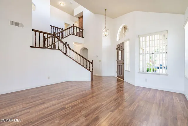 wooden floor in an entryway with a window