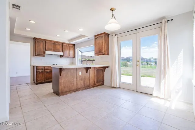 a large kitchen with stainless steel appliances granite countertop a stove a sink and a refrigerator