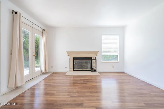 wooden floor fireplace and windows in an empty room