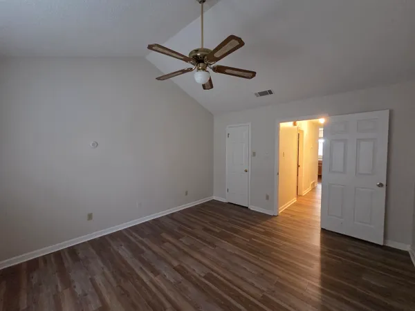 a view of a room with wooden floor and ceiling fan