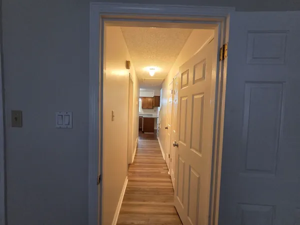 a view of a hallway with wooden shelves