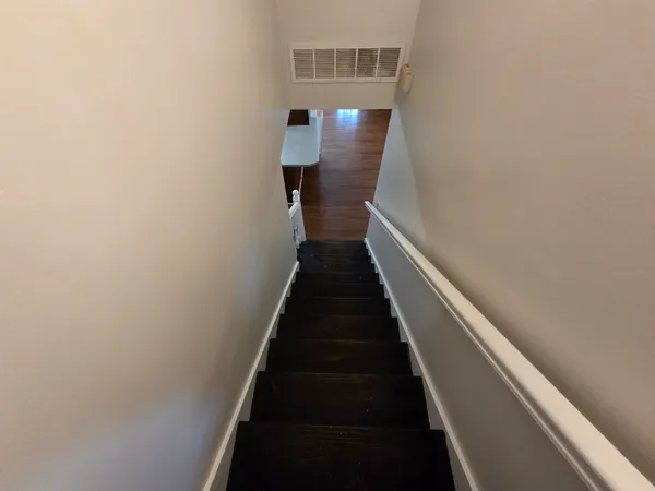 a view of a hallway with wooden floor and staircase