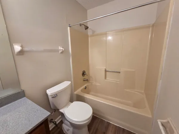 a white toilet sitting next to a bath tub