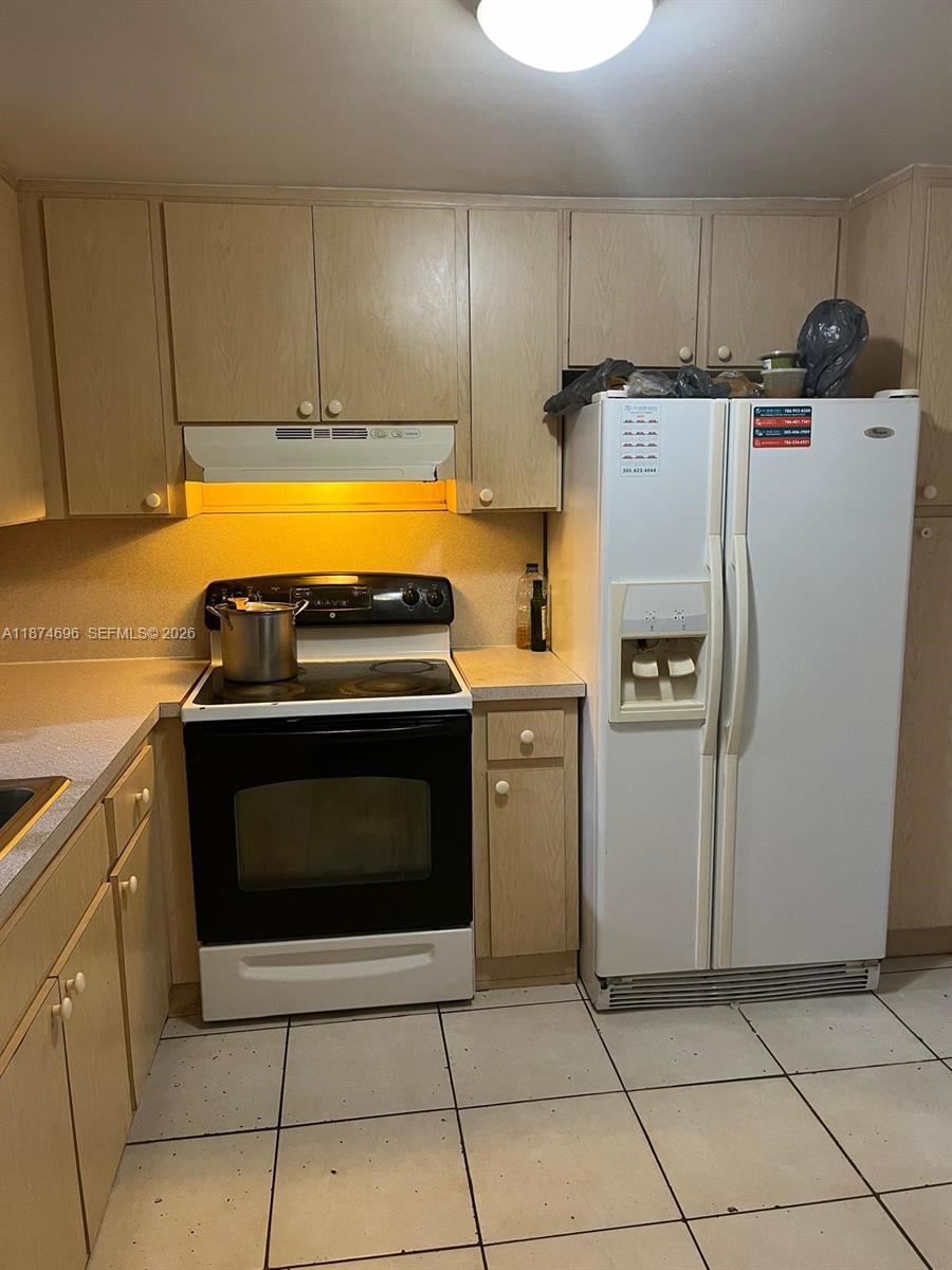 11295 Southwest 88th Street, Unit M109 Miami, FL 33176 - Photo 5 of 17 a kitchen with a stove top oven and cabinets
