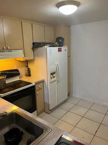 a kitchen with refrigerator and window