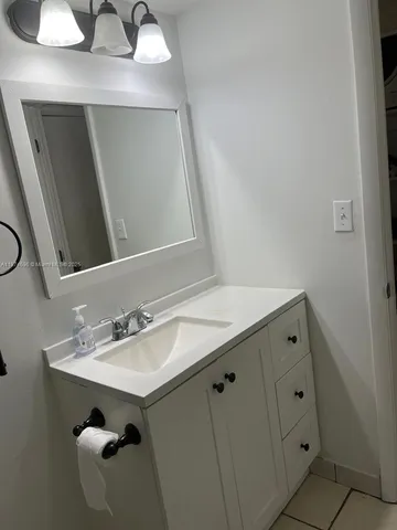 a bathroom with a sink vanity and mirror
