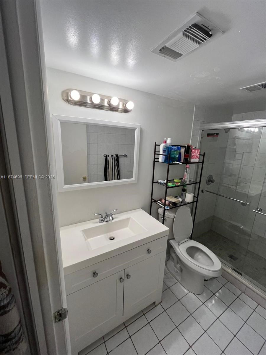 11295 Southwest 88th Street, Unit M109 Miami, FL 33176 - Photo 9 of 17 a bathroom with a toilet sink and mirror