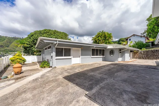 a front view of a house with a garden and outdoor seating