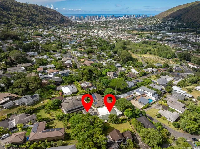 an aerial view of residential houses with cars parked