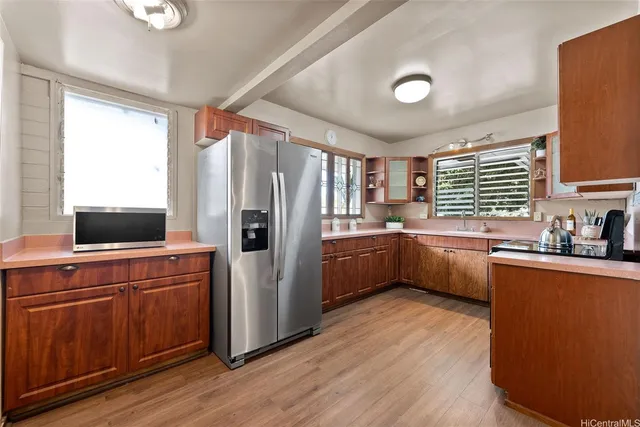a kitchen with stainless steel appliances a refrigerator sink and wooden floor