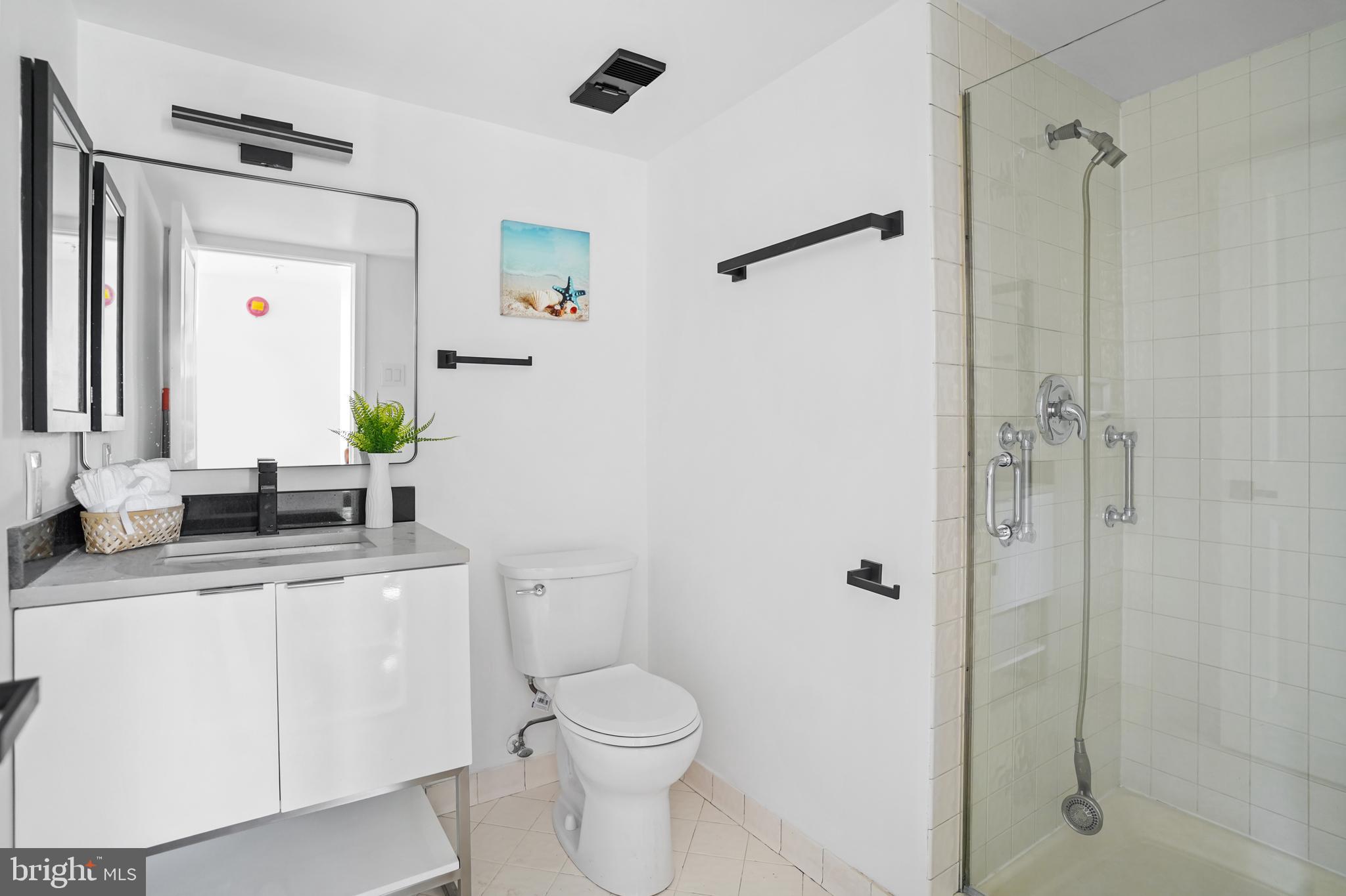 5000 Battery Lane, Unit 501 Bethesda, MD 20814 - Photo 9 of 21 a bathroom with a granite countertop sink toilet and shower