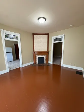 an empty room with a fireplace and window