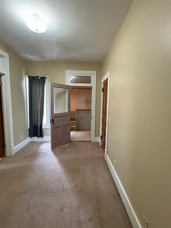 an empty room with a cabinet and mirrors