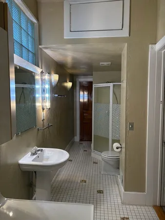 a bathroom with a sink a toilet a mirror and shower