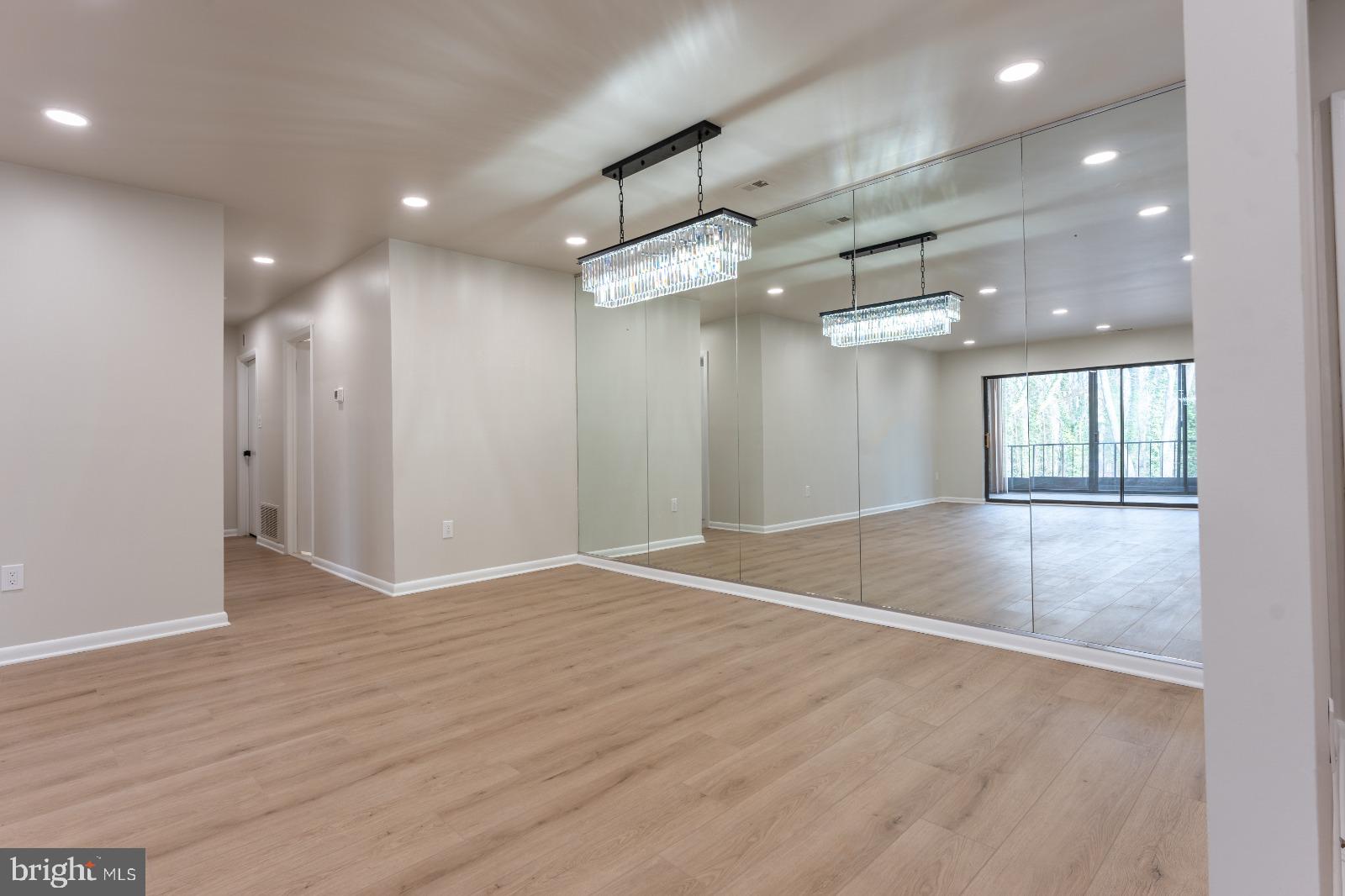 6350 Red Cedar Place, Unit 309 Baltimore, MD 21209 - Photo 15 of 29 an empty room with wooden floor and windows