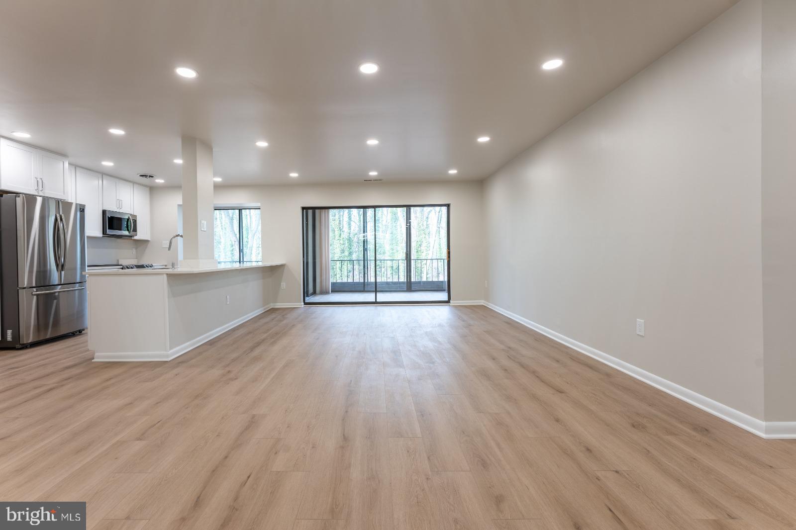 6350 Red Cedar Place, Unit 309 Baltimore, MD 21209 - Photo 17 of 29 a view of an empty room with wooden floor and a window