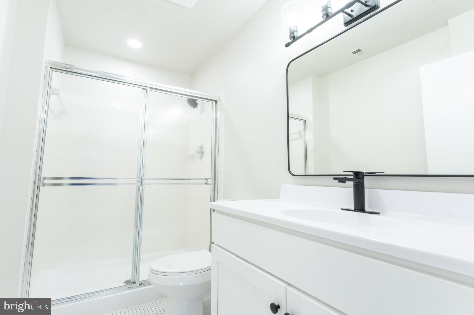 6350 Red Cedar Place, Unit 309 Baltimore, MD 21209 - Photo 21 of 29 a bathroom with a sink a toilet and a mirror