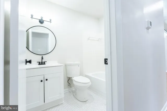 a bathroom with a toilet a sink and a mirror